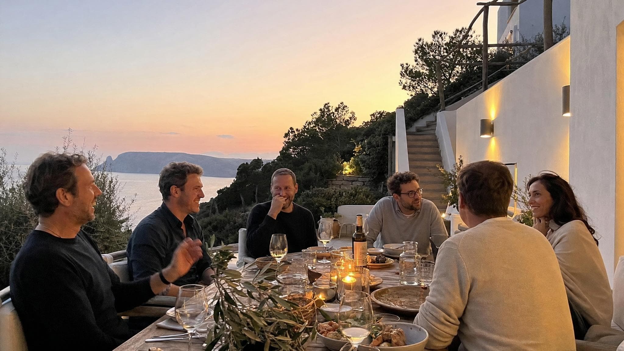 FATFIRE members at a sunset dinner on a clifftop terrace overlooking the sea