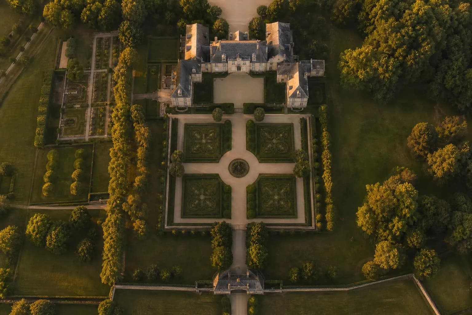 Aerial view of a formal estate with manicured gardens and structured pathways, suggesting generational planning and stewardship.