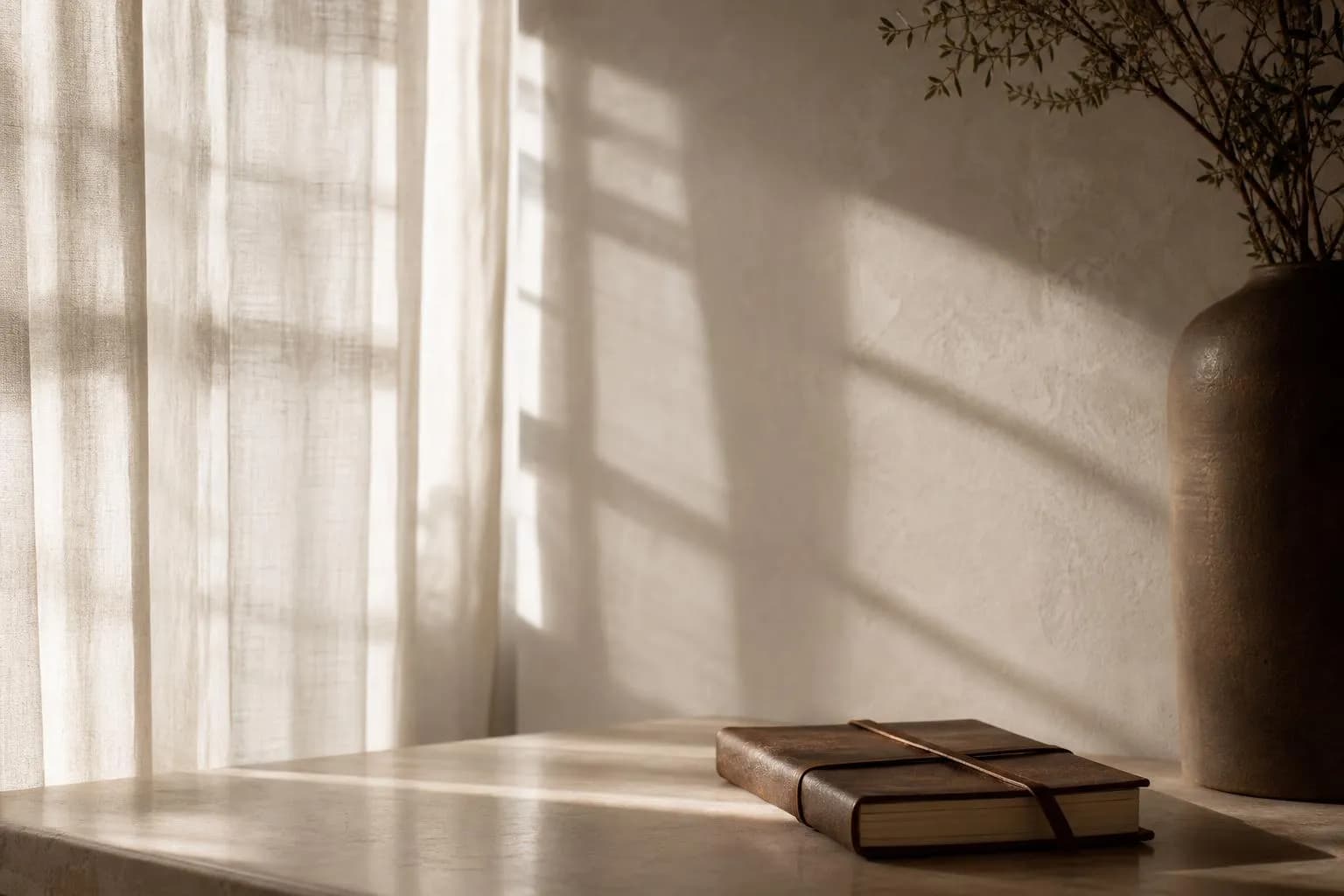 Soft sunlight through linen curtains casting gentle shadows on a minimalist wall
