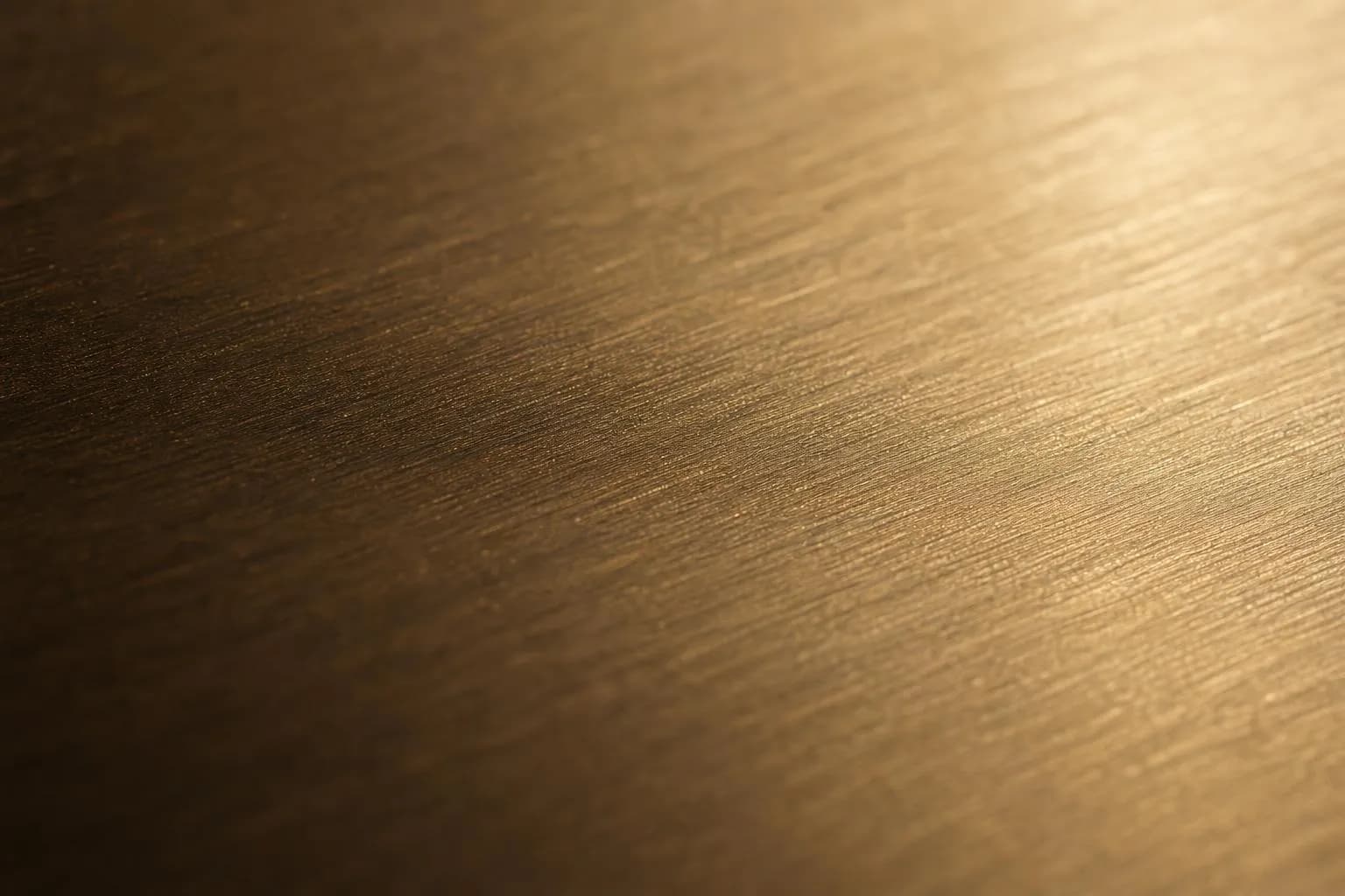 Extreme close-up of brushed brass surface with directional texture and warm patina