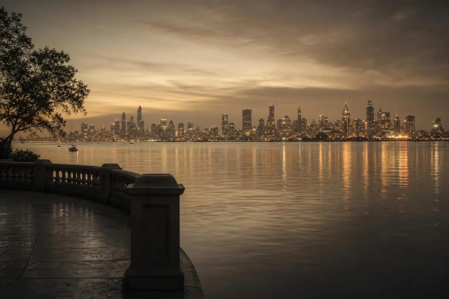 Calm harbor at dusk, distant city lights reflected in still water across a wide expanse.