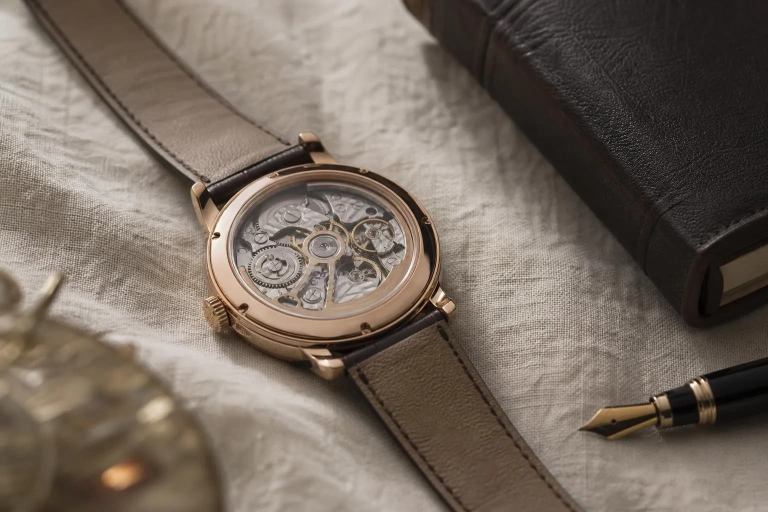 Luxury watch on linen with ledger and pen, symbolizing patient wealth accumulation