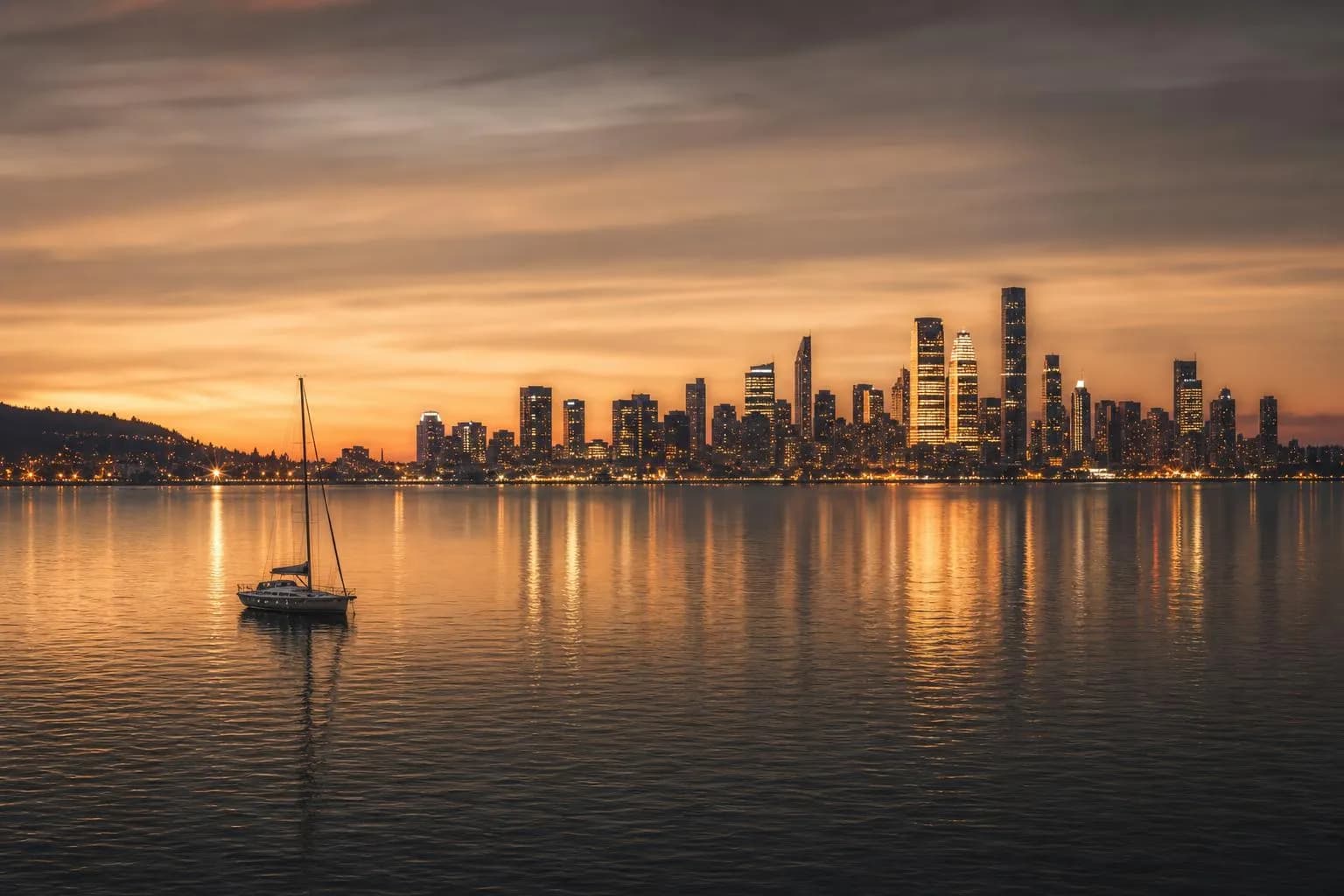 Distant city skyline at dusk reflected in calm harbor water, with a solitary boat in the foreground.