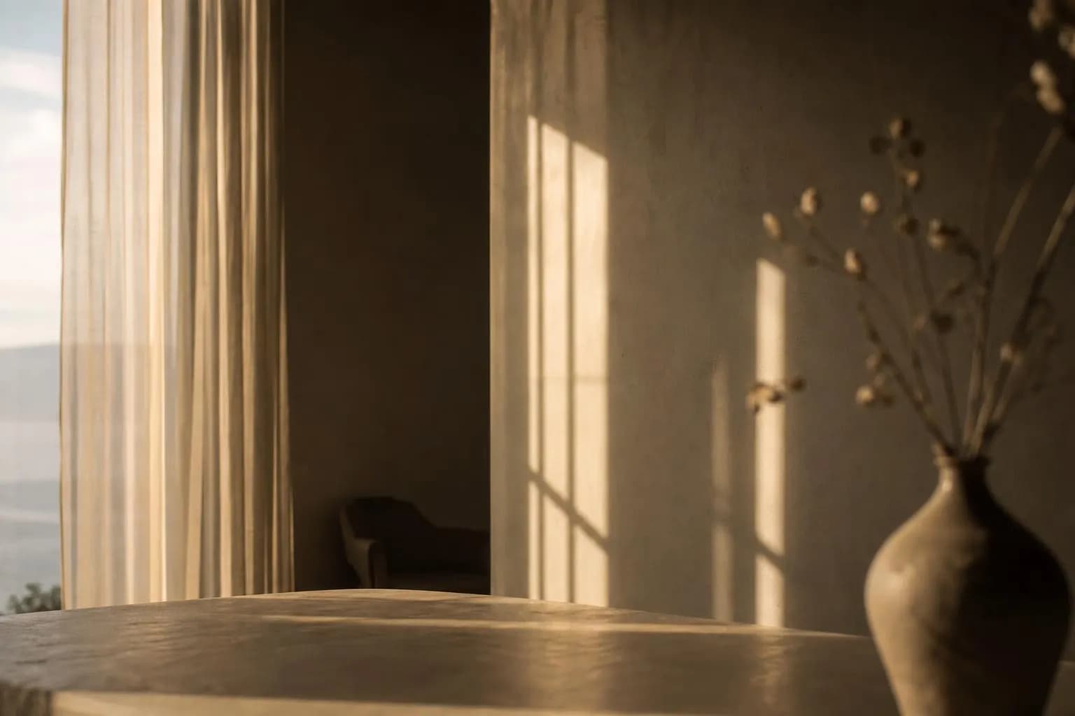 Sunlight streaming through sheer curtains casts soft shadows on a pale wall