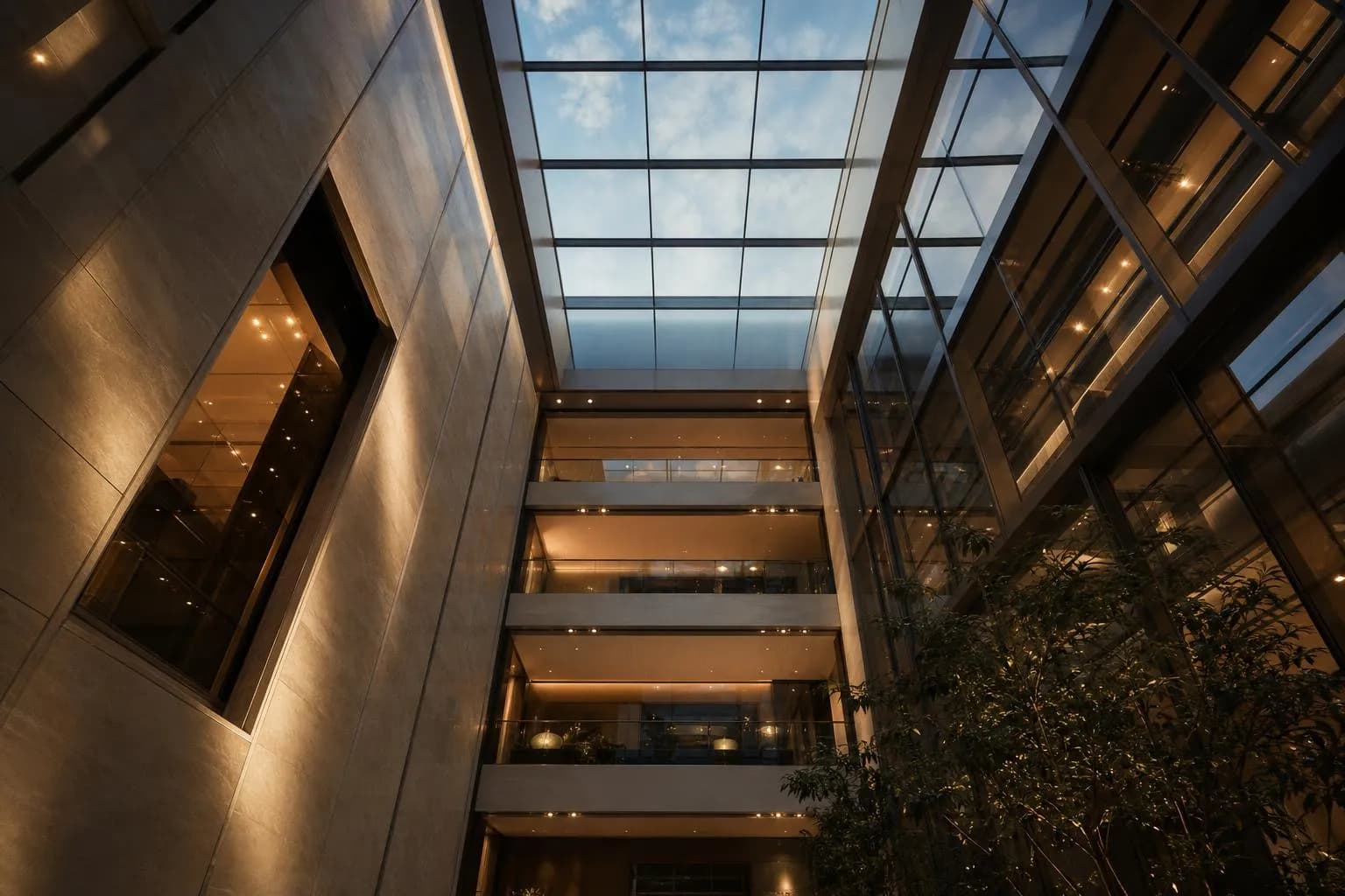 Modern atrium interior viewed from below, geometric glass and steel architecture with natural light from above.