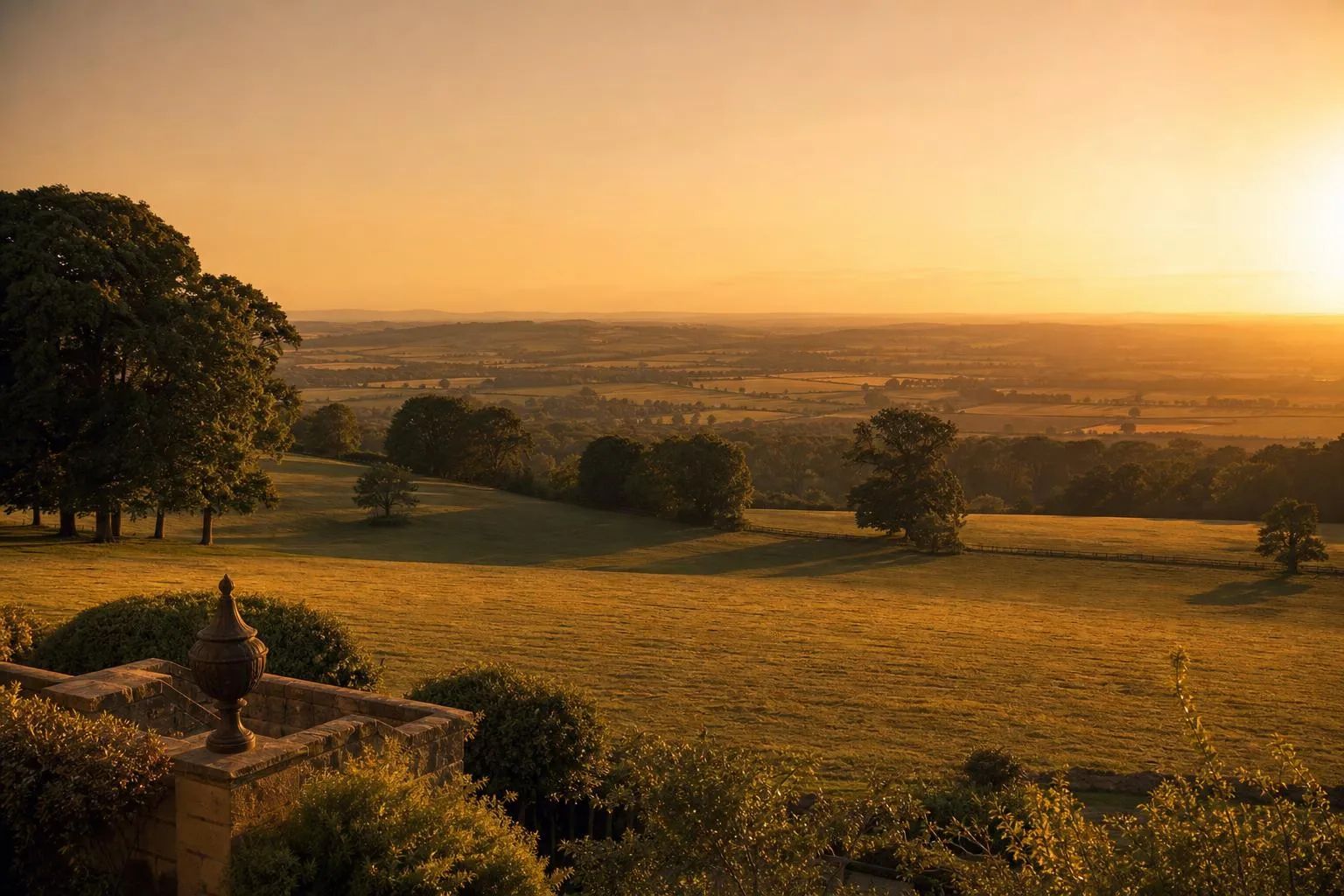 Rolling countryside bathed in golden-hour light, receding to a hazy horizon.