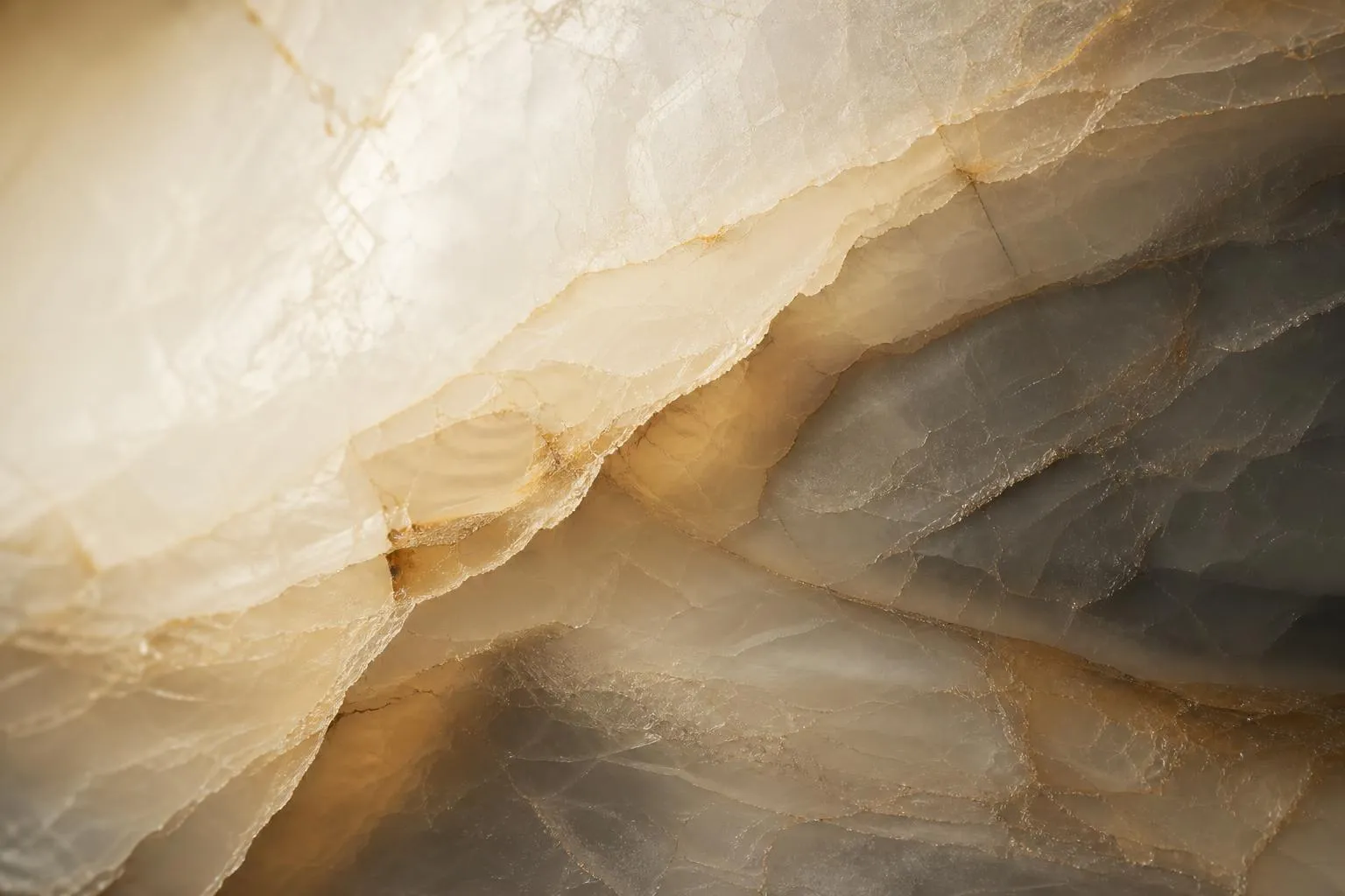 Close-up of layered marble with delicate veining, backlit to show translucent depth and subtle variation.